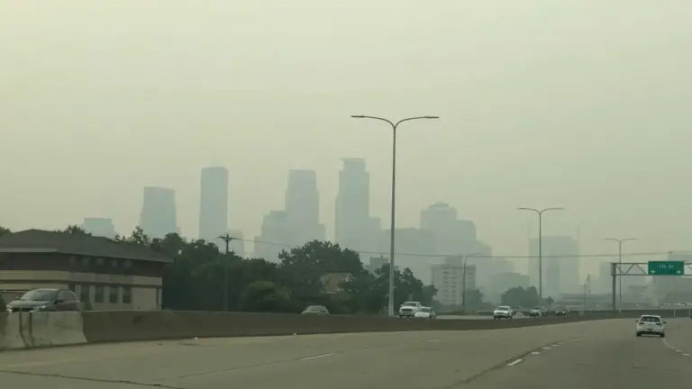 Image of smog with barely visible Minneapolis skyline, from the perspective of the highway. Image from Bring Me the News