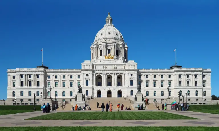 The facade of the Minnesota State Capitol on a sunny day with blue skies.