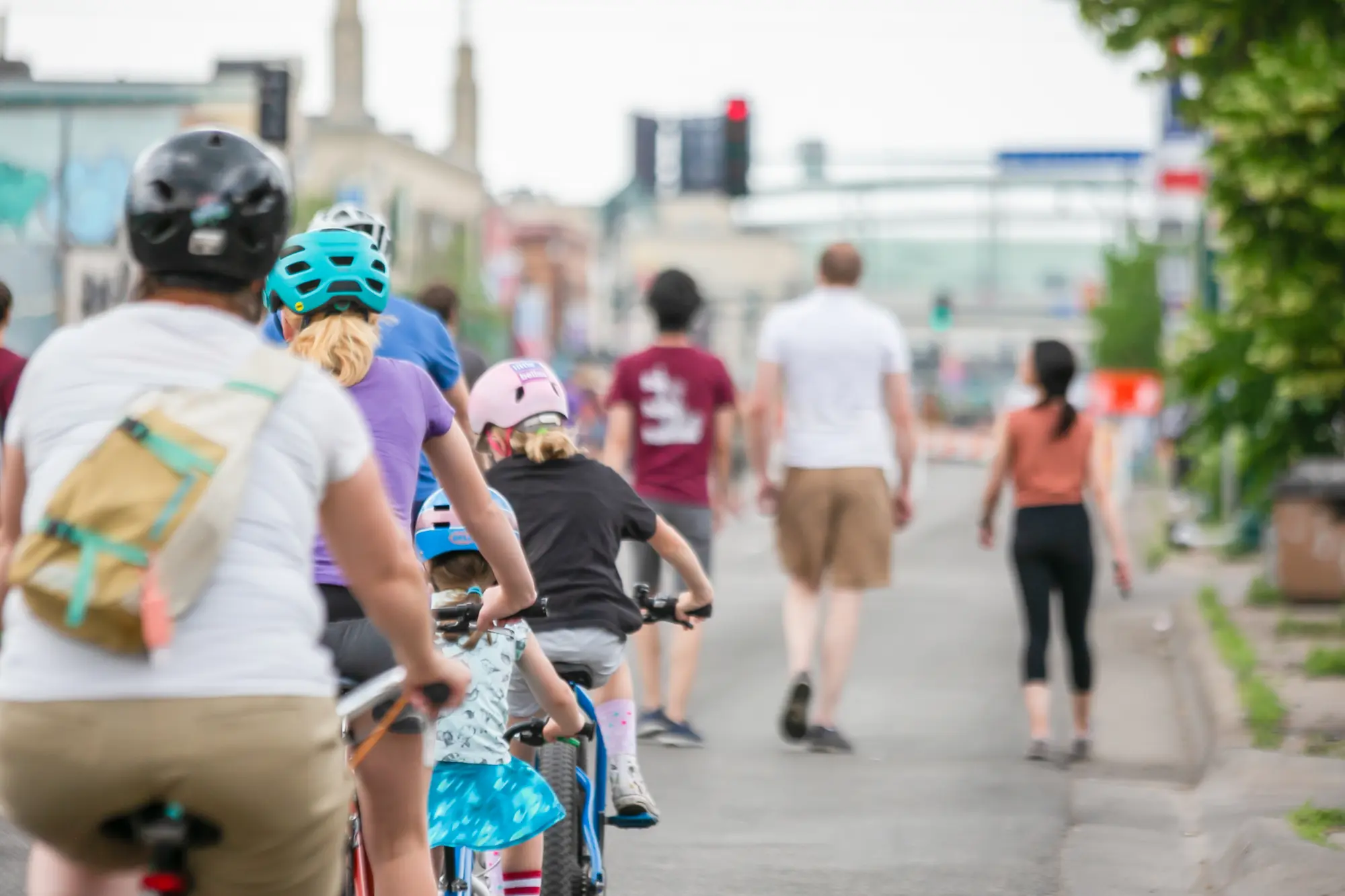 people biking and walking on a street.