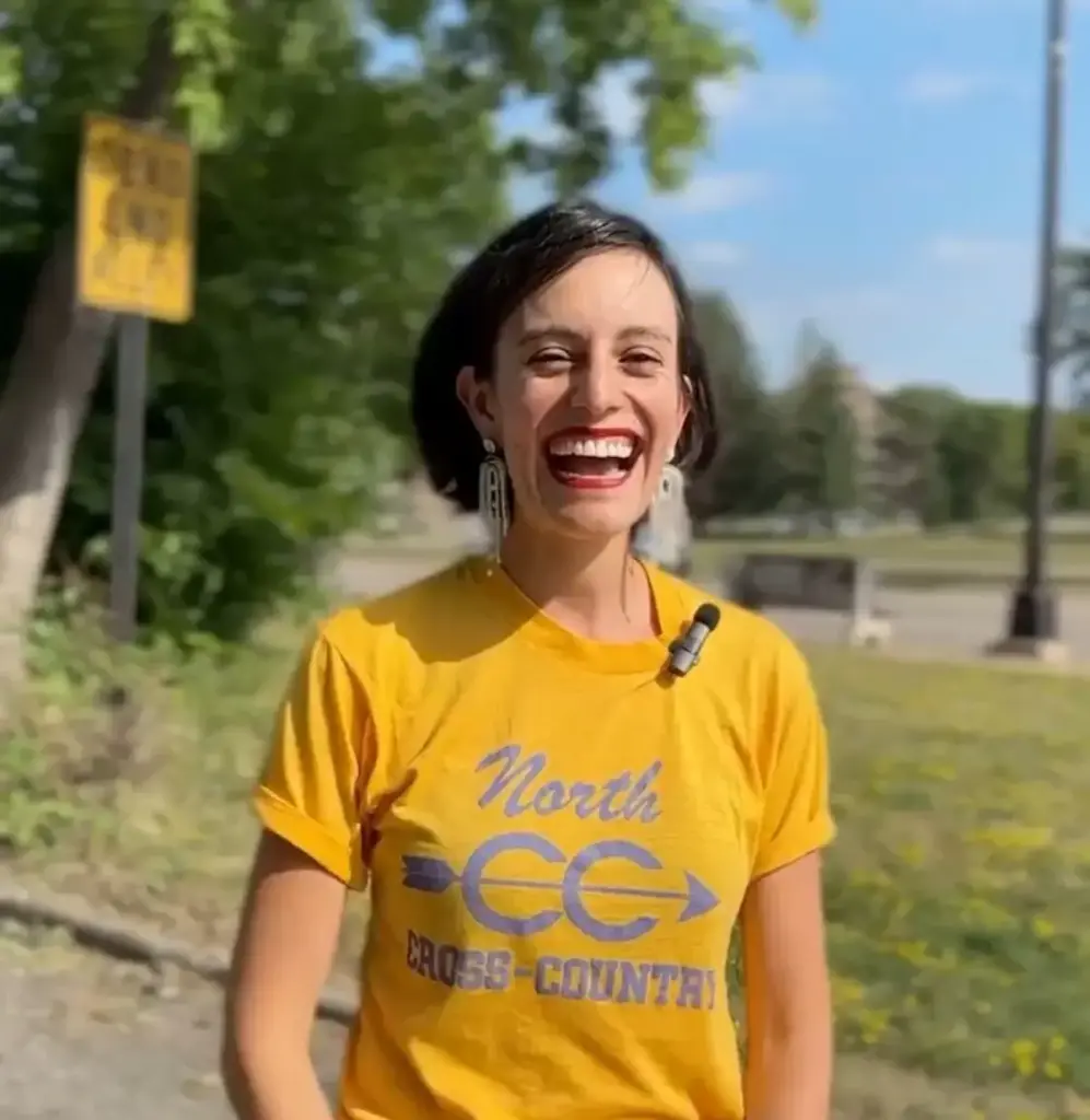 Sonya in a yellow shirt smiling in front of Olson