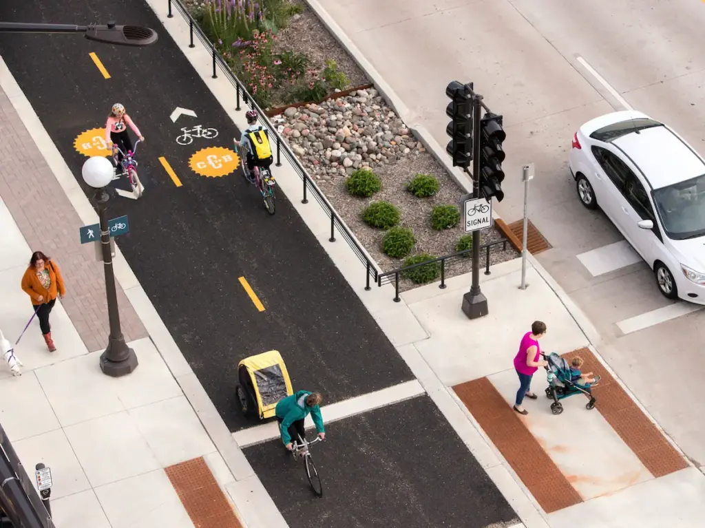 Aerial image of separated bike land with greenery and raised curb separating bikers from car traffic. (Toole Design Group)