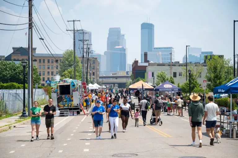 People enjoying a closed-down Glenwood Avenue with the Minneapolis skyline in the background.