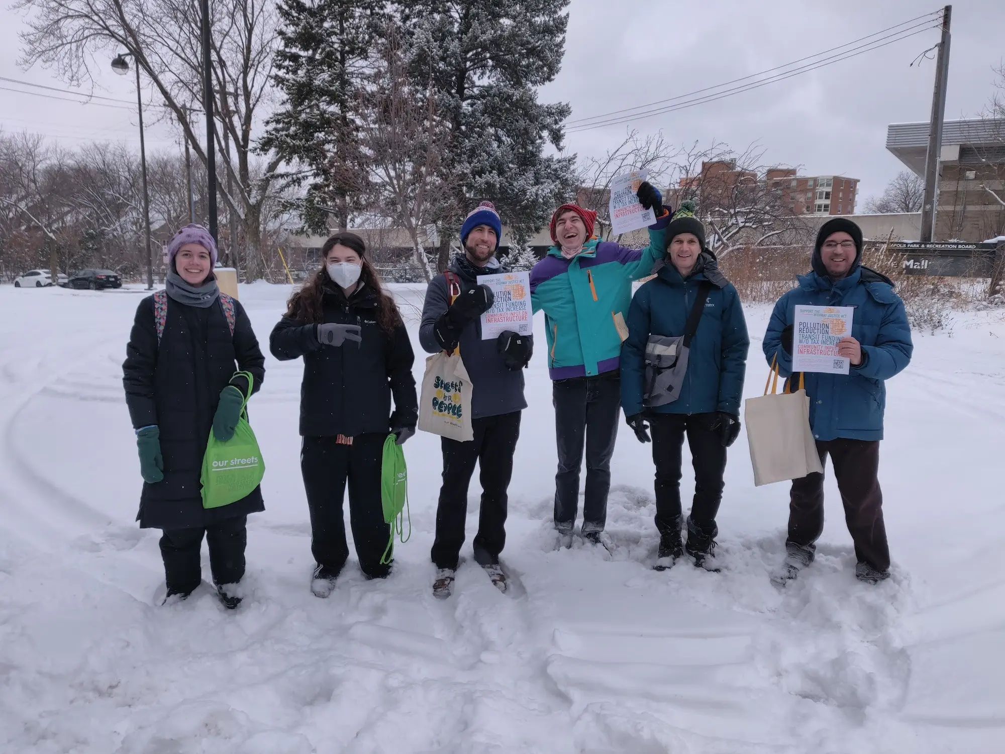 canvassers and volunteers pose for a group photo in the snow during a doorknocking event
