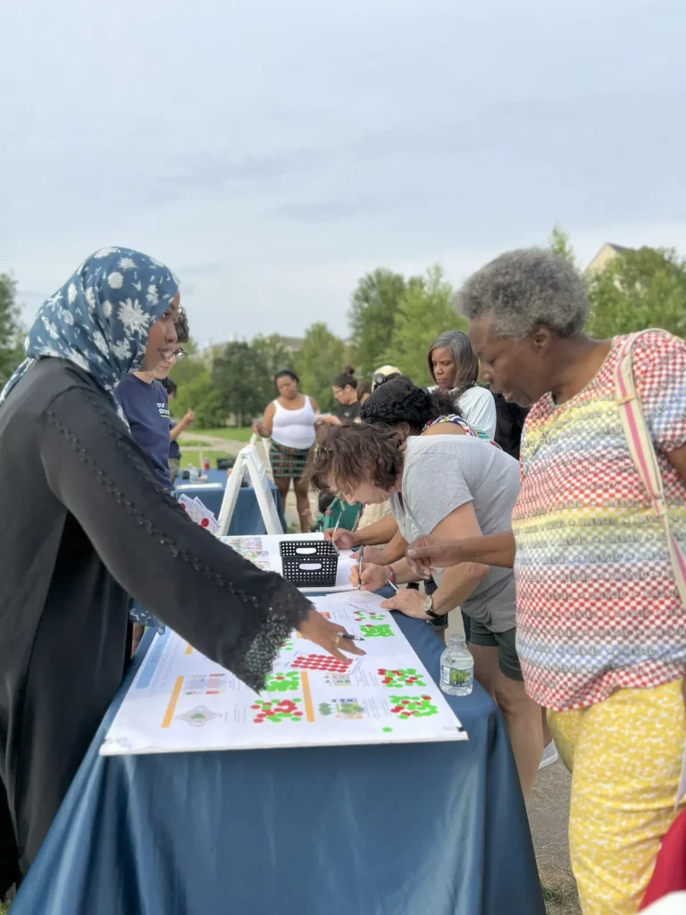 Our Streets staff sharing community visions for Olson Memorial Highway at Heritage Park National Night Out.