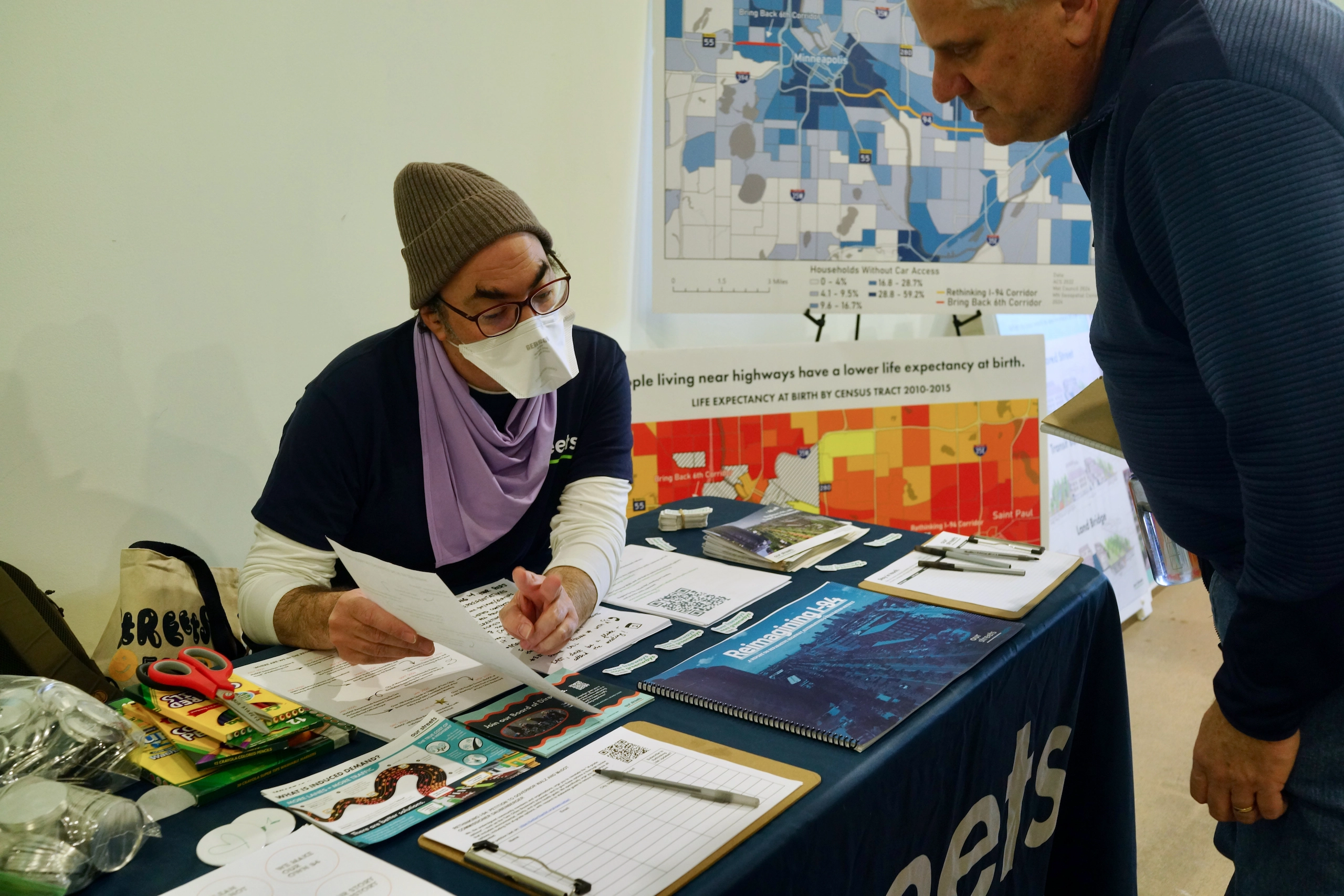 Our Streets canvasser talking with an attendee.