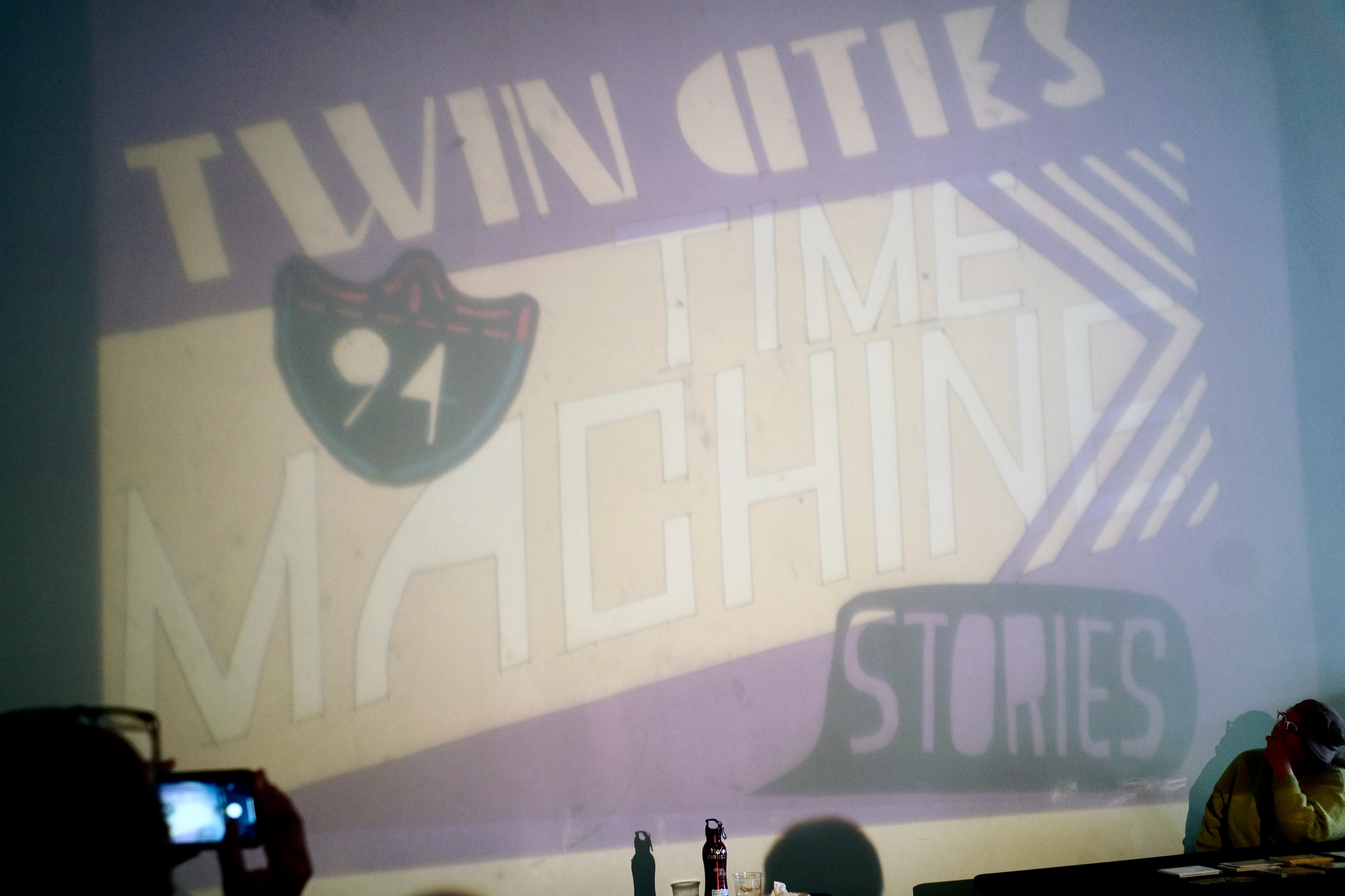 A big screen projecting that says, "Twin Cities Time Machine: 94 Stories".