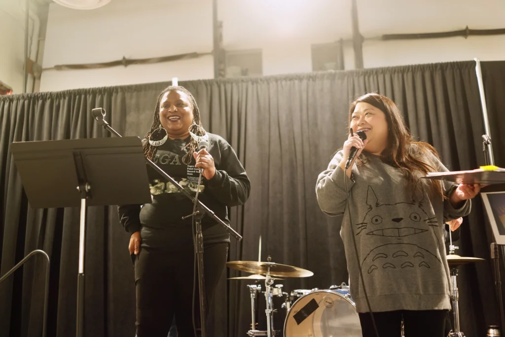 94 Stories Time Machine emcees, Nicole Smith (left) and May Lee-Yang (right) speaking.
